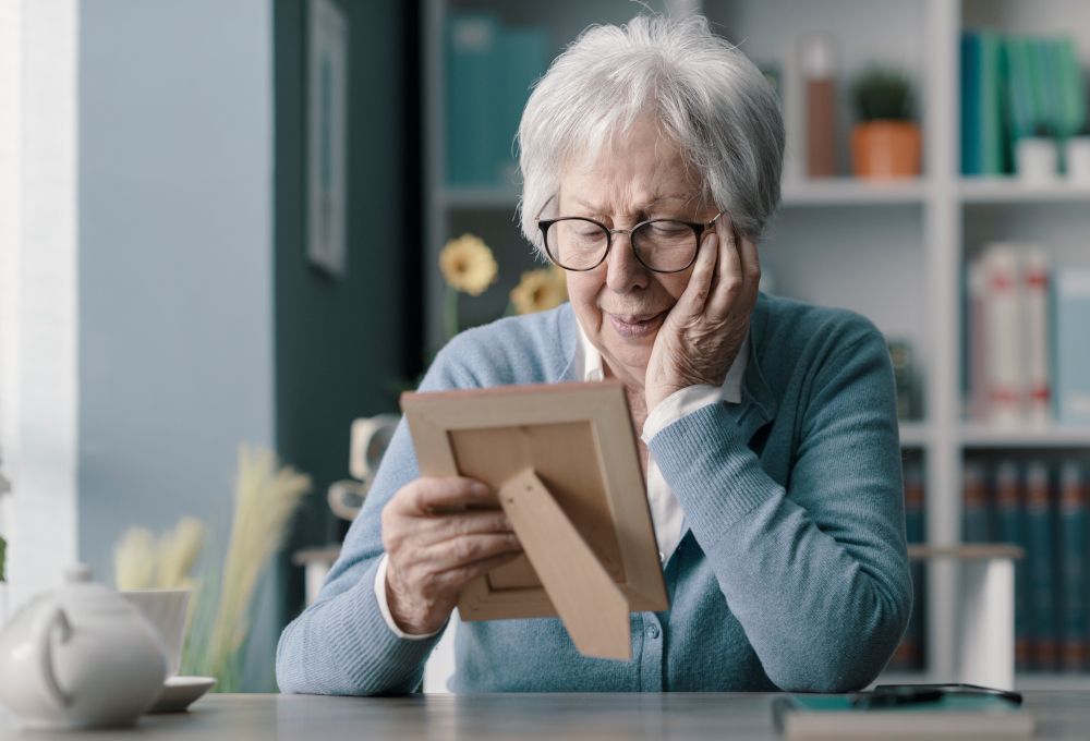Una señora mirando una foto pasando por un proceso de duelo.