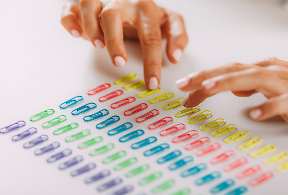 Una chica que sufre TOC colocando los clips por colores y filas. Concepto de trastornos obsesivos compulsivos.